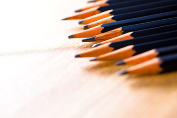 Obraz premium black pencils isolated on wood surface background.Close up.
