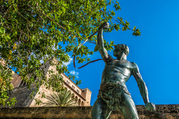SPAIN, MALLORCA ,PALMA, Statue of a stone slinger below the Almudaina palace in Palma. The...