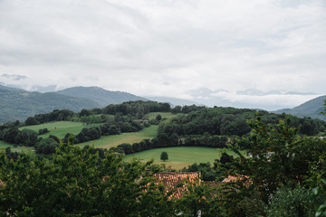 Fototapeta premium European rural country side highland village view. Photography of houses on the edge of mountain forest and clody sky.