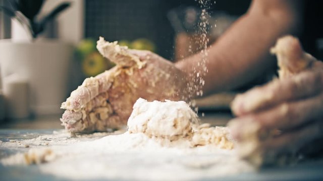 Pouring wheat flour on bread dough, slow motion close-up shot