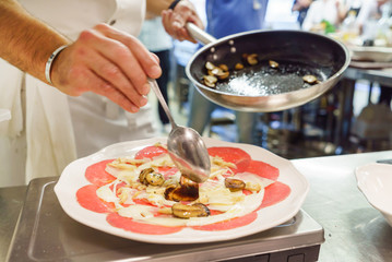 chef making beef carpaccio in the restaurant