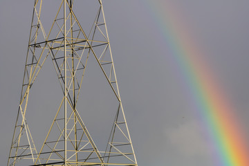 Electrical power grid pole and a rainbow