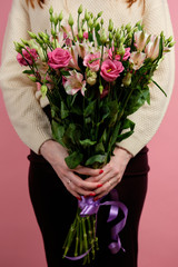 A tall bouquet of pink alstromeries and eustomas in the hands of a red-haired girl