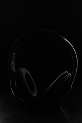 Fototapeta na wymiar large black wireless headphones on a black background.vertical photo