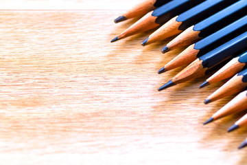 Obraz premium black pencils isolated on wood surface background.Close up.