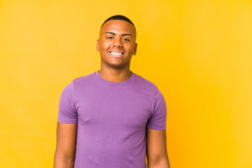 Young latin man isolated on yellow background happy, smiling and cheerful.