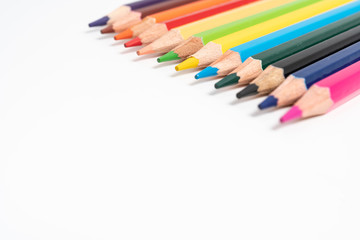 many colored pencils on white background