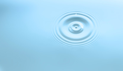 Water drop and circle ripple, light blue water, close up