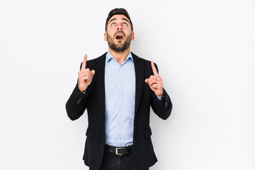 Young caucasian business man against a white background isolated pointing upside with opened mouth.
