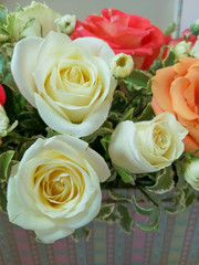 A bright bouquet of different colors roses, decorated with green twigs.