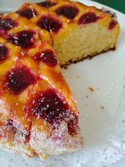 Sponge cake decorated with cherry jam and coconut shavings.