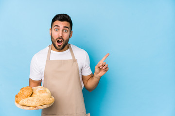 Young handsome baker man isolated pointing to the side - obrazy, fototapety, plakaty