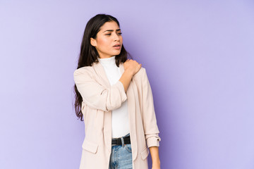 Young indian woman isolated on purple background having a shoulder pain.