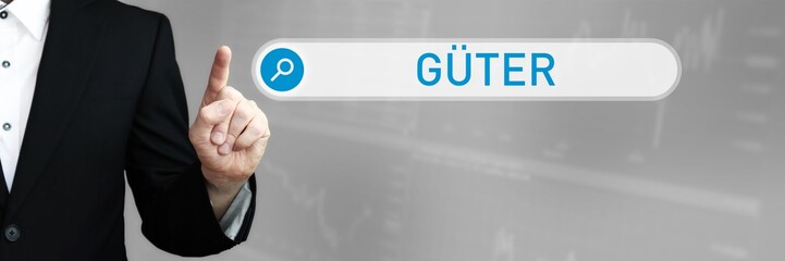 Güter. Mann im Anzug zeigt mit dem Finger auf ein Suchfeld. Das Wort Güter steht in der Suche....