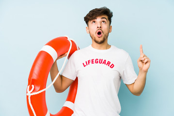 Young arabian lifeguard man isolated  pointing upside with opened mouth.