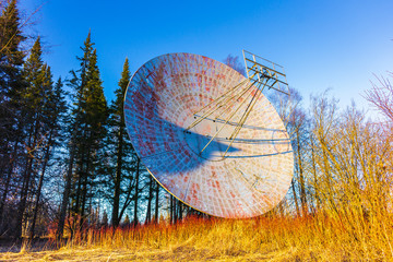 large radio astronomy telescope antenna in the forest broadcast signal