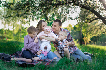 Fototapeta premium Family having a great time in the park. Father hugs son. Happy family on nature.