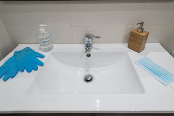 Sink with material to prevent coronavirus (covid-19), hydroalcoholic gel, soap, gloves and mask.