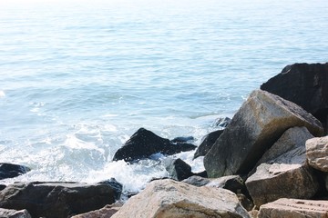 The stormy sea. Waves are breaking on stones. Rocky coast in the ocean.