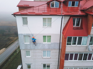 Industrial climber paints the facade of a new building