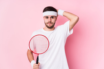 Young caucasian man playing badminton isolated being shocked, she has remembered important meeting.