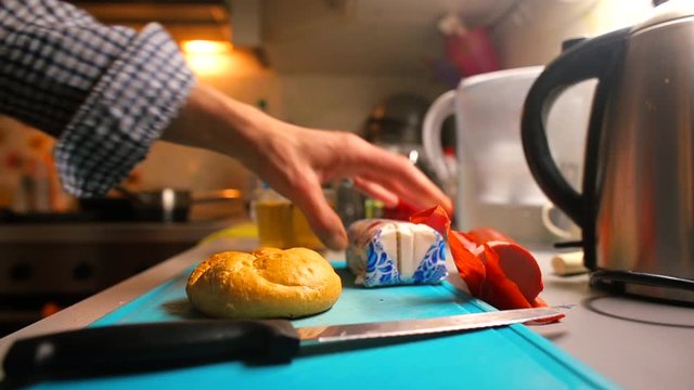 A man puts the ingredients for making a sandwich on the table. Cooking concept.