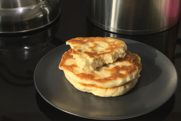Food in a bowl on a black surface. Pancakes made from flour, on a black plate. Cooking homemade food.