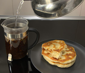 Pita bread and tea for breakfast. Brew tea with boiling water in a teapot. Pour boiling water into the dishes. Cooking a light meal.