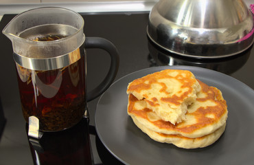 Pita bread and tea for dinner. Brewed black tea in a teapot. Hot drink in a glass bowl. Cooking a light meal.
