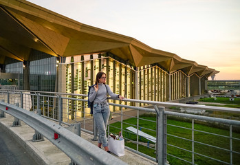 Young girl on the background of the airport building .