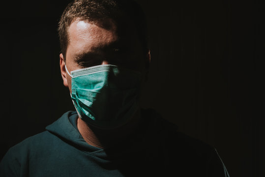 Man Wearing Mask For Protection From Corona Viruse Covid-19 On Dark Background