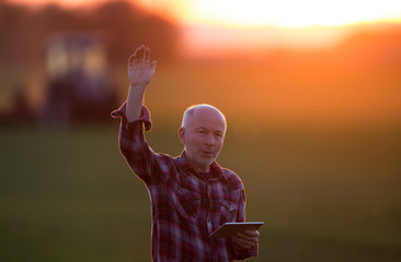 Farmer with tablet standing in field