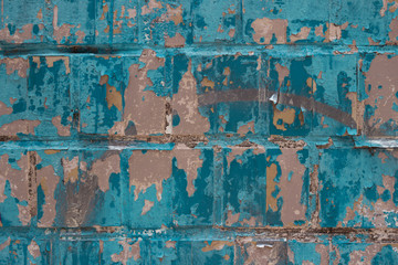 An old tile wall is punctured in tit color. Cracked paint, aged texture, background