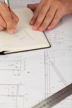 Cropped image of a professional draftsman correcting a blueprint