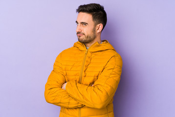 Young caucasian man isolated on purple background unhappy looking in camera with sarcastic expression.