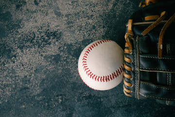 Baseball glove and ball flat lay on grunge texture backdrop, copy space on background for sport.  Isolated sports equipment.