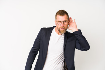 Senior business man isolated on white background trying to listening a gossip.