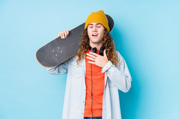 Young caucasian skater man isolated laughs out loudly keeping hand on chest.