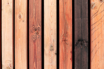 Wooden background. Rustic wooden fence made from treated differently colored boards. Tinted.