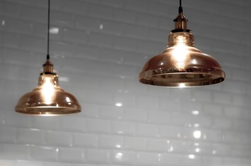 Softly focus of 2 vintage glass ceiling lamps in bronze color tone with blurred white tiles wall...