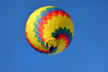 beautiful multi-colored hot air balloon in the blue sky close up