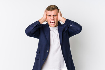 Young business caucasian man covering ears with hands trying not to hear too loud sound.