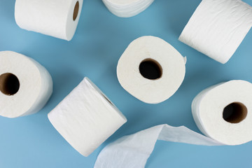 Top view of rolls of toilet paper on blue background