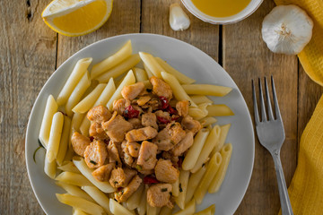 Mediterranean food - penne pasta and  chicken in a creamy sauce on a yellow napkin.