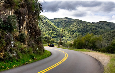 Isolated car parked on the side of winding road in the mountains