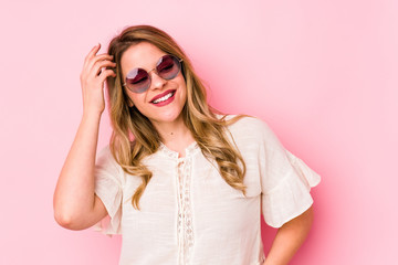 Young caucian woman with glasses isolated on pink background joyful laughing a lot. Happiness concept.