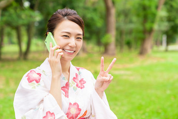 Fototapeta premium 浴衣を着た女性 電話