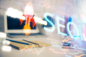 Multi exposure of table with computer and seo drawing hologram. Search optimization concept.