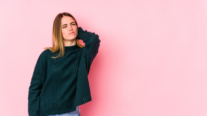 Young caucasian woman isolated on pink background having a neck pain due to stress, massaging and touching it with hand.