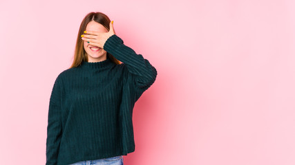 Young caucasian woman isolated on pink background covers eyes with hands, smiles broadly waiting for a surprise.